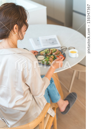 一位女士在餐桌旁用餐的背影 一位女士在餐桌旁用餐的背影 138347367