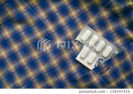 A blister pack of medicinal capsules in a shirt pocket 138347416