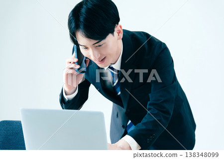 一個年輕的商人在辦公室打電話 138348099