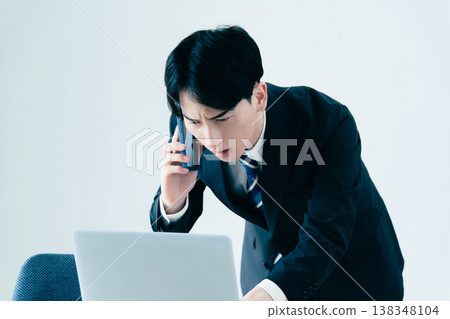 一個年輕的商人在辦公室打電話 138348104