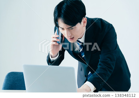 A young businessman calling in the office A young businessman calling in the office 138348112