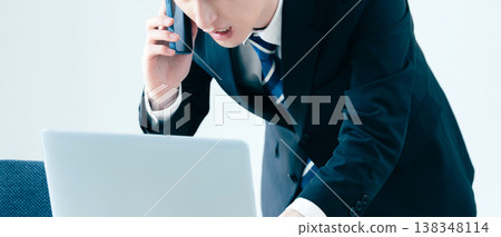 一個年輕的商人在辦公室打電話 138348114