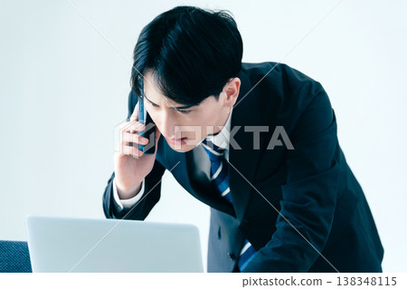 一個年輕的商人在辦公室打電話 138348115