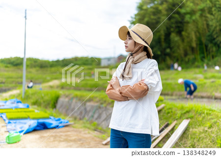 A female farmer gazing at the rice fields 138348249
