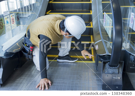 工人正在檢查自動扶梯 工人正在檢查自動扶梯 138348360