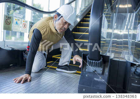 Workers inspecting escalators 138348363