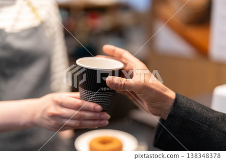 咖啡館女員工遞上一杯外帶咖啡。 138348378