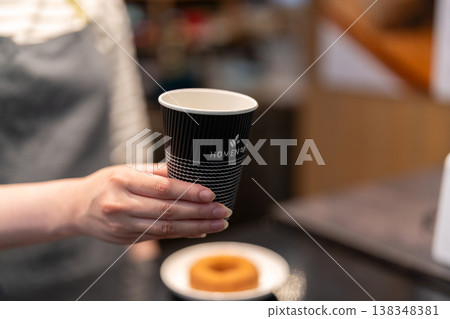咖啡館女員工遞上一杯外帶咖啡。 138348381