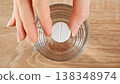 Close-up Female Hand Holding Tablet Above Glass Of Water, Top View. Medication, Supplement Dosage, Preparation And Daily Healthcare Routine Concept. 138348974