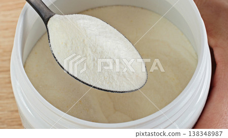 Close-up Collagen Powder Serving On Spoon Above Container. Macro view. Beauty And Skincare Nutrition Supplement Concept. Close-up Collagen Powder Serving On Spoon Above Container. Macro view. Beauty And Skincare Nutrition Supplement Concept. 138348987