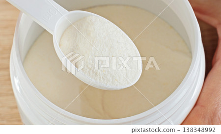 Close-up Scooping Protein Powder With Measuring Scoop From Container. Sports Nutrition And Fitness Supplement Concept. Close-up Scooping Protein Powder With Measuring Scoop From Container. Sports Nutrition And Fitness Supplement Concept. 138348992