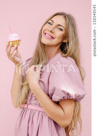 Happy Woman Holding Pink Cupcake With Candle Happy Woman Holding Pink Cupcake With Candle 138349145