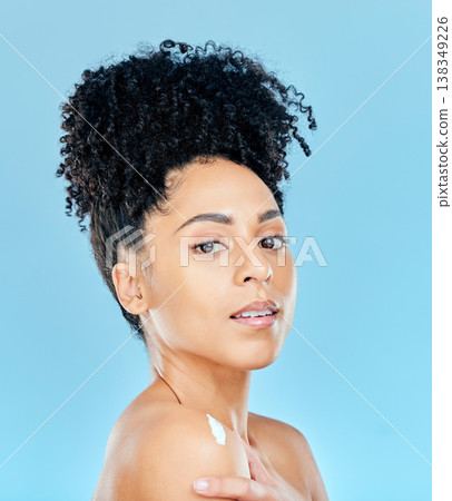 Beauty, studio portrait and woman with body cream application, dermatology product or lotion for skin hydration glow. Spa salon wellness, shoulder creme and aesthetic model shine on blue background Beauty, studio portrait and woman with body cream application, dermatology product or lotion for skin hydration glow. Spa salon wellness, shoulder creme and aesthetic model shine on blue background 138349226