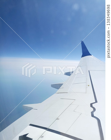 May 18, 2023. The sky between Belarus and the United Arab Emirates. A view from an airplane window of a blue sky, white clouds, and an airplane wing May 18, 2023. The sky between Belarus and the United Arab Emirates. A view from an airplane window of a blue sky, white clouds, and an airplane wing 138349698