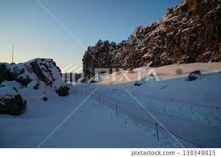 Walking through winter in Gján under a blue sky - Iceland 138349815