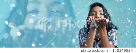 Blowing glitter, woman and portrait with double exposure and sparkle in a studio with celebration. Blue background, female person and confetti with modern fashion, surprise and silver decoration Blowing glitter, woman and portrait with double exposure and sparkle in a studio with celebration. Blue background, female person and confetti with modern fashion, surprise and silver decoration 138349824