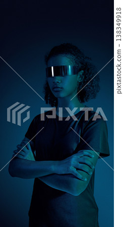 Female teenager athlete standing with crossed arms in minimal dark studio with blue light. 138349918