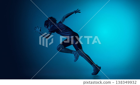 Teenager athlete performing running jump in studio wearing futuristic visor 138349932