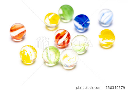色彩繽紛的玻璃彈珠在白色背景的襯托下拍攝的照片。 138350379