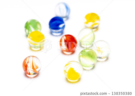 Product photography material featuring brightly colored marbles lined up against a white background. Product photography material featuring brightly colored marbles lined up against a white background. 138350380