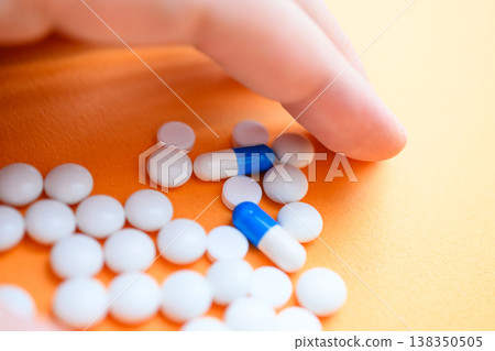 Close-up of finger and pill Close-up of finger and pill 138350505