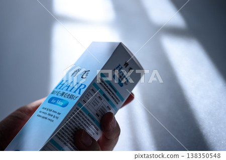 手裡拿著一盒男士生髮劑 手裡拿著一盒男士生髮劑 138350548