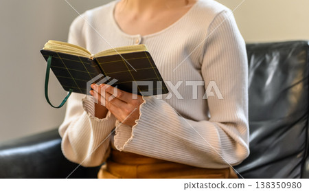 A woman's hands holding an open notebook. A woman's hands holding an open notebook. 138350980