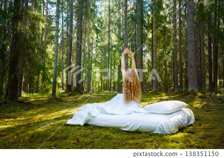 Girl wakes up in a summer forest Girl wakes up in a summer forest 138351150