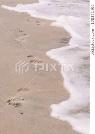Footsteps on beach near water Footsteps on beach near water 138351166