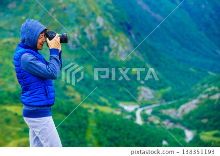 Tourist with camera and in Norway mountains Tourist with camera and in Norway mountains 138351193