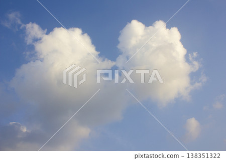 It's a blue sky with atmospheric puffy clouds. 138351322