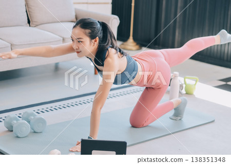 Young Asian sporty attractive people practicing yoga lesson with instructor. Asia group of women exercising healthy lifestyle in fitness studio. Sport activity, gymnastics or ballet dancing class. 138351348