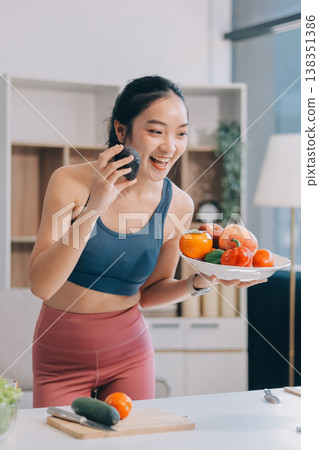 Fit young Asian women in activewear sitting on yoga mat and eating fresh vegetable salad after workout, representing clean eating, fitness lifestyle, wellness routine and health balance. Fit young Asian women in activewear sitting on yoga mat and eating fresh vegetable salad after workout, representing clean eating, fitness lifestyle, wellness routine and health balance. 138351386