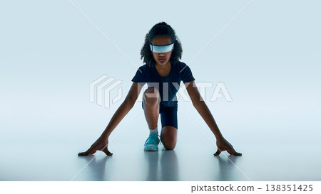 Teen athlete in starting pose wearing reflective futuristic visor in minimal studio background. Teen athlete in starting pose wearing reflective futuristic visor in minimal studio background. 138351425