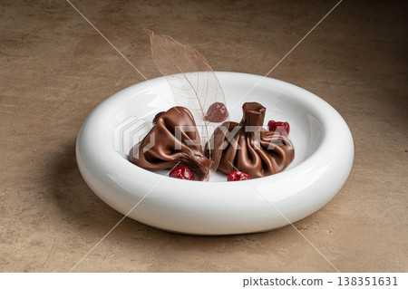 Chocolate dessert shaped like khinkali on plate Chocolate dessert shaped like khinkali on plate 138351631