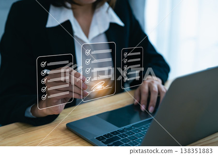 Business professional reviewing digital checklists on a laptop while completing tasks and managing project deadlines in a modern workspace environment Business professional reviewing digital checklists on a laptop while completing tasks and managing project deadlines in a modern workspace environment 138351883