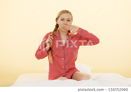 Sleepy young woman wearing cute pink pajamas Sleepy young woman wearing cute pink pajamas 138352060