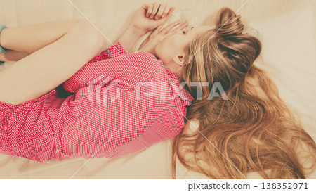 Young woman lying on bed wearing pajamas 138352071