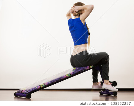 Woman training on bench for sit ups 138352237