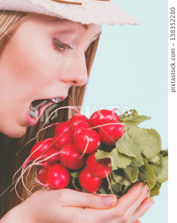 Happy woman biting radish Happy woman biting radish 138352280