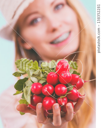 Happy woman giving radish Happy woman giving radish 138352281