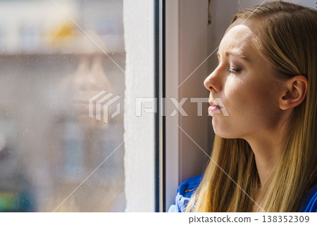 Woman relaxing on windowsill Woman relaxing on windowsill 138352309
