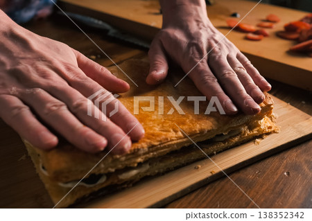 Folding layers of puff pastry pie with filling. Folding layers of puff pastry pie with filling. 138352342