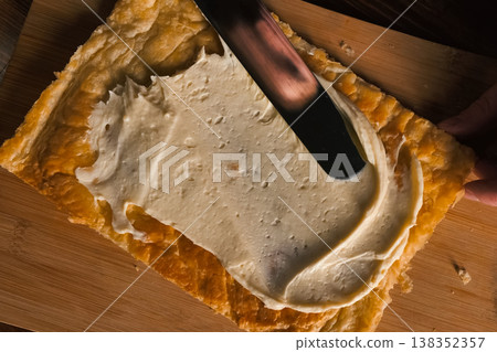 Smearing the cream over the layers of cake dough. Pie filling. Smearing the cream over the layers of cake dough. Pie filling. 138352357