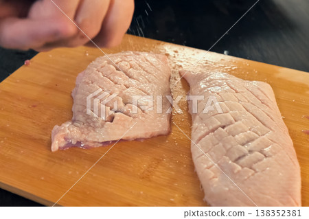 slicing chicken breasts on cutting board, cooking poultry meat. slicing chicken breasts on cutting board, cooking poultry meat. 138352381