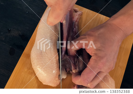 Cutting poultry meat. Broiler breast, chicken meat on cutting board. Cutting poultry meat. Broiler breast, chicken meat on cutting board. 138352388