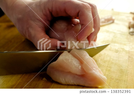 Cutting poultry meat. Broiler breast, chicken meat on cutting board. Cutting poultry meat. Broiler breast, chicken meat on cutting board. 138352391