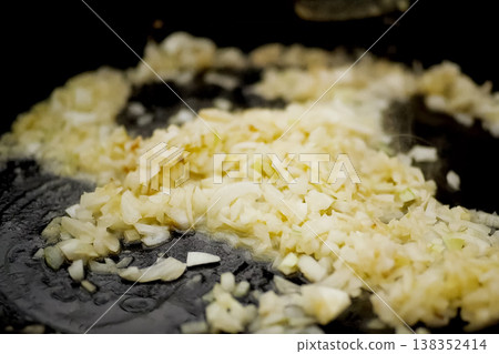 Roasting onions in pan with oil on fire. Roasting onions in pan with oil on fire. 138352414