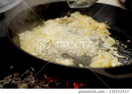 Roasting onions in pan with oil on fire. Roasting onions in pan with oil on fire. 138352417