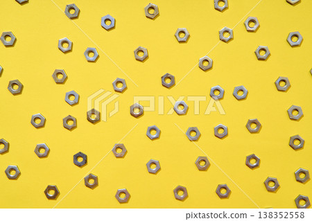 Metal nuts pattern on yellow background 138352558